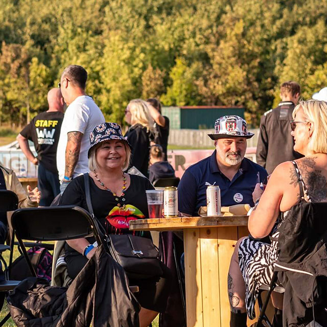 Festival-goers sitting outside in the sun